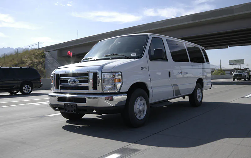 A white van on the freeway that is used as a rideshare vehicle. Using rideshare apps and groups can also make a big difference in winter-time traffic in the canyons.