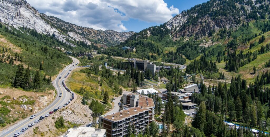 Aerial view of Snowbird during Oktoberfest showing traffic along SR-210, roadside parking, and the resort in Little Cottonwood Canyon.