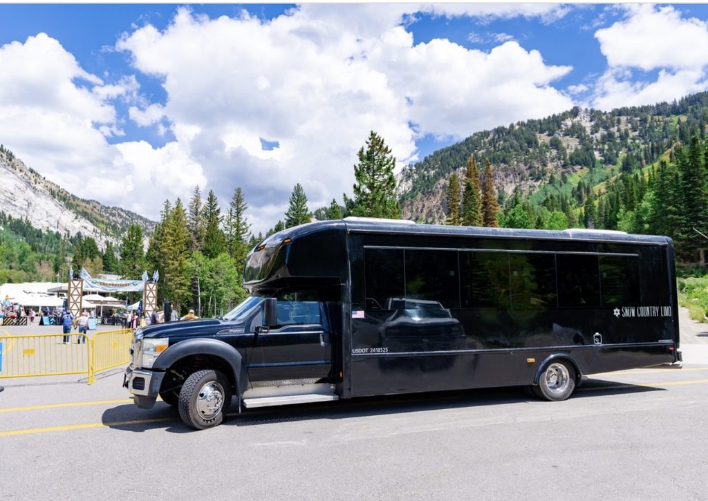 Snow Country Limo shuttle parked outside the entrance to Snowbird Oktoberfest in Little Cottonwood Canyon.